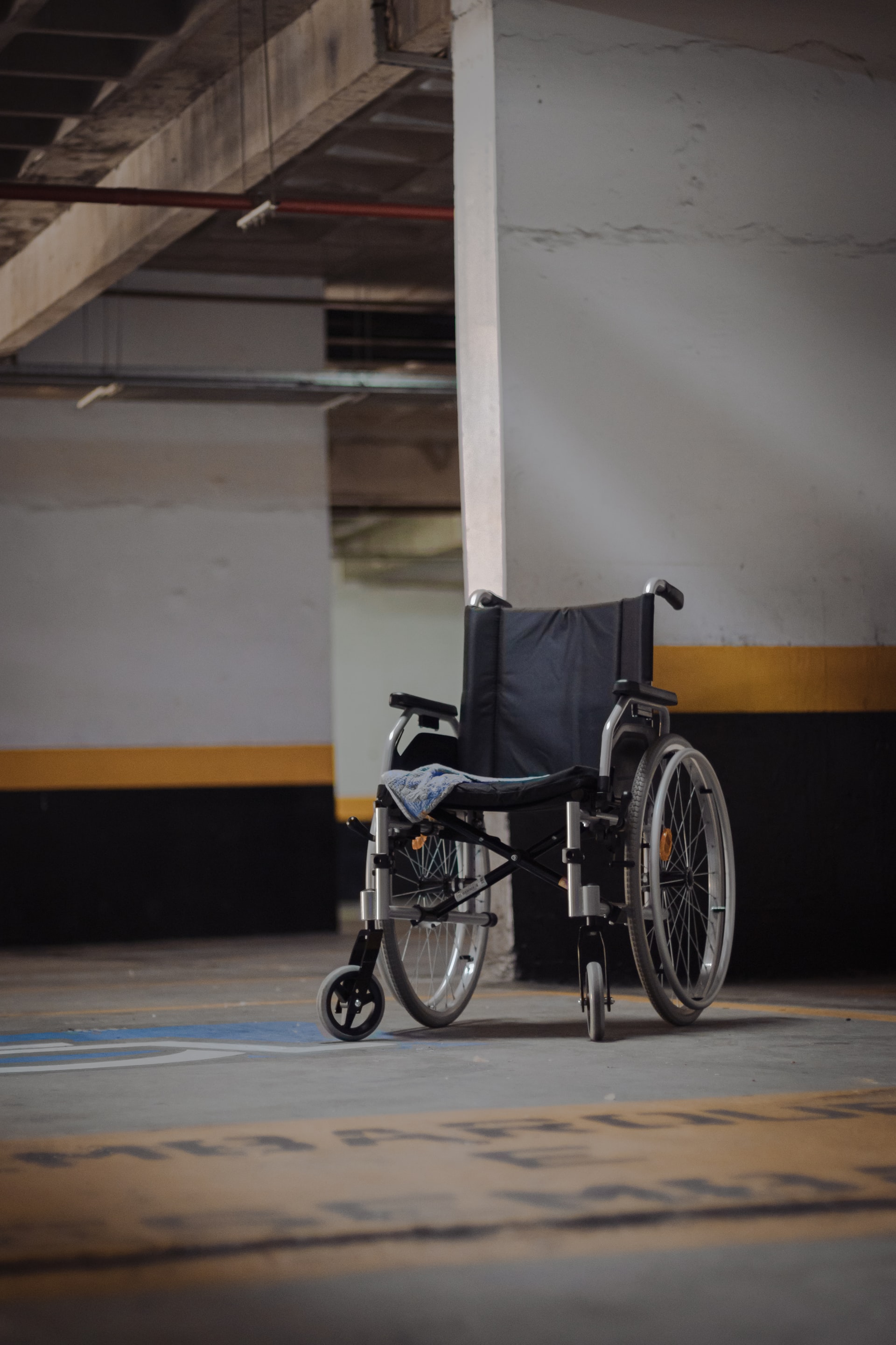 Un fauteuil roulant vide dans un parking souterrain